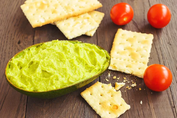 Avocado cream,biscuits and small tomatoes — Stock Photo, Image