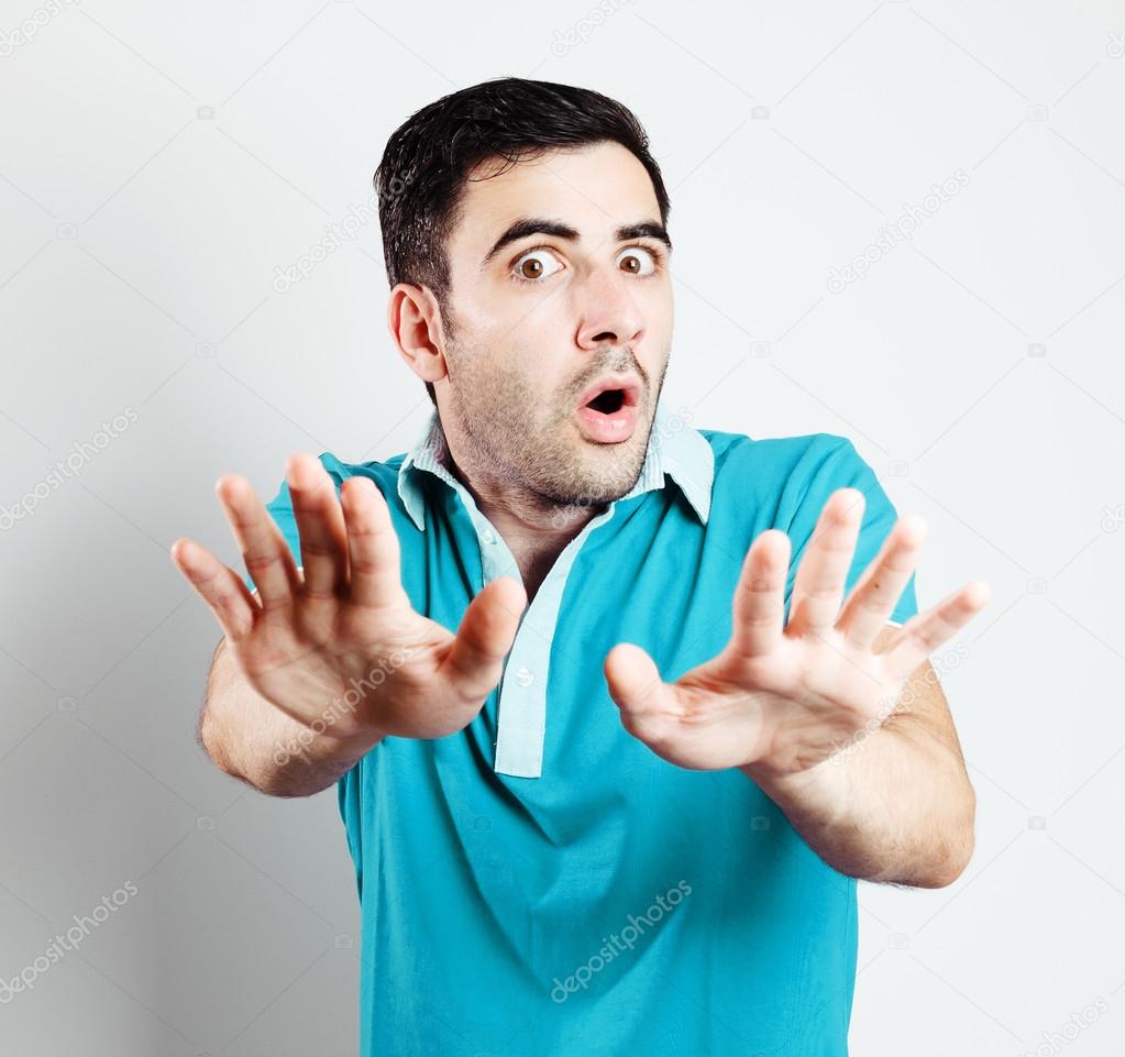 Caucasian male with blue shirt being scared in front of camera