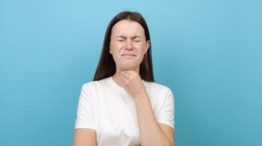 Sağlıksız genç bir kadın boğazına dokunur yutması zordur. Rahatsızlık ya da acı hisseder. Anjinden muzdarip üzgün bir kız, boğazı ağrır.