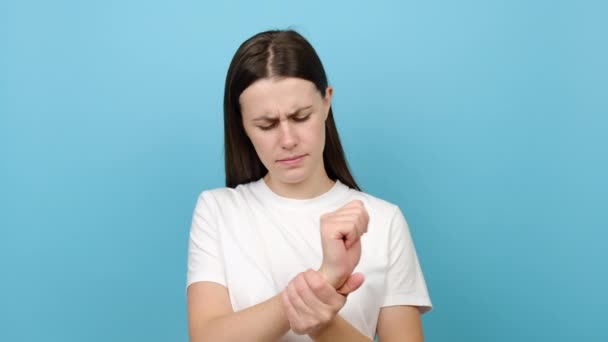Jonge Vrouw Masseren Hand Lijden Aan Gewrichtspijn Geïsoleerd Blauwe Achtergrond — Stockvideo