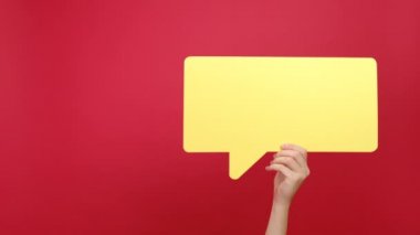 Sarı kağıt hashtag sembolü ve konuşma baloncuğu tutan kadın eller, kırmızı arka plandaki stüdyoda izole edilmiş ünlü medya içeriğinin esrar işareti. Viral ağ paylaşımı, blog web sitesi stratejisi kavramı