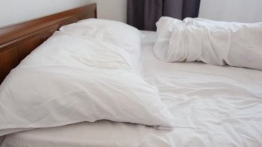 20 'li yaşlarda sakin, genç, beyaz bir kadının seçici odak noktası sağlıklı ve güzel bir uyku uykusunun tadını çıkararak rahat, yeni bir yatakta uyur. Milenyum bayanı beyaz yatağa giriyor ve uyuyor.