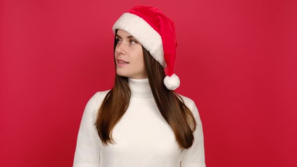 秘密的年轻黑发女子说 安静的沉默与手指上的嘴唇嘘手势 穿着毛衣和圣诞帽 隔离在红色工作室的背景 庆祝新年快乐假期的概念 — 图库视频影像