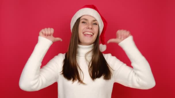 자신의 손가락을 내밀고 믿음직 스웨터와 크리스마스 모자를 녹음실의 배경에 고립되어 — 비디오