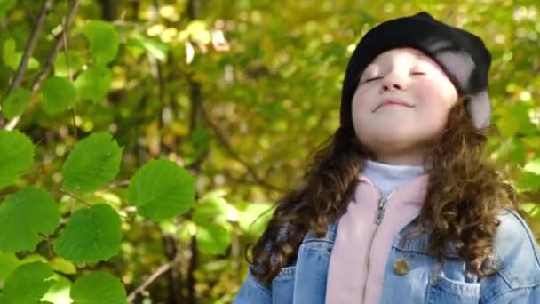 形象可爱的小女孩呼吸新鲜空气 深呼吸 减少秋天森林里的压力 梦幻般的淡然微笑的孩子呼吸着新鲜的空气 平静快乐的学生在户外 — 图库视频影像
