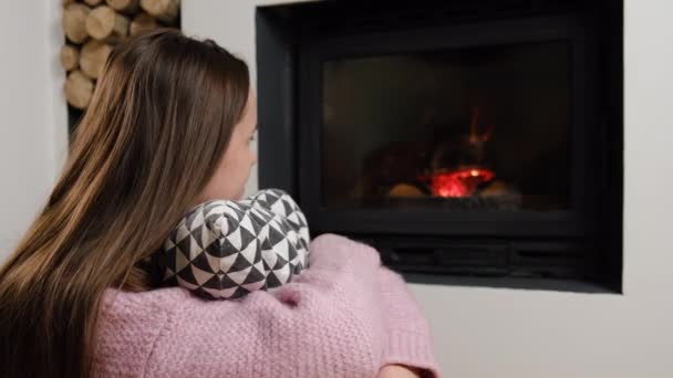 在舒适的壁炉边的地板上抱着枕头的冷静年轻的高加索女人的选择性聚焦 在现代乡村村舍里享受周末 冬季和假期的概念 — 图库视频影像