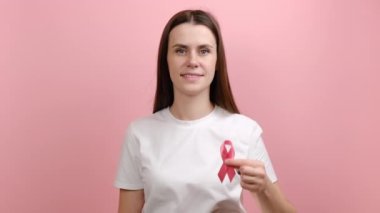 Elinde pembe kurdele, meme kanseri farkındalığının sembolü, kanser önleme tavsiyesi ve uyarısı, stüdyo geçmişinde izole edilmiş kadın sağlığı teşhisi.