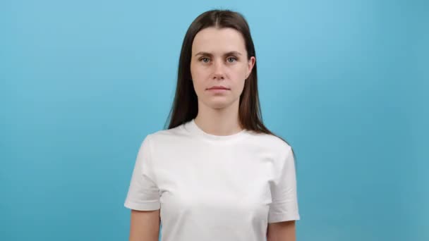 美しい女性の健康診断 病気の予防 スタジオで青の色の背景に隔離されたポーズ ピンクのリボン 乳がんの意識の象徴を示す白いTシャツの愛らしい若い女性 — ストック動画