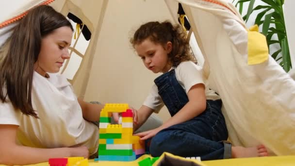 Jovem Mãe Ajuda Filha Construir Com Blocos Coloridos Criança Brincar — Vídeo de Stock
