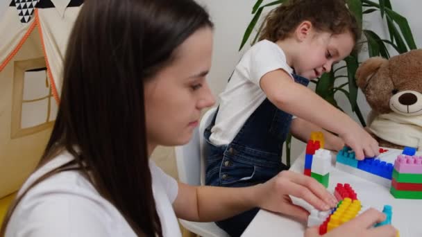 Junge Mutter Und Süße Tochter Sitzen Tisch Warmen Kinderzimmer Spielen — Stockvideo