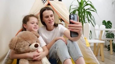 Sevimli, gülümseyen, küçük kızı olan genç bir anne. Telefonla kendini videoya çekip sosyal medya sohbeti için videoya çekiyor. İnternet üzerinden Kafkas ailesi vlogger etkileyicisi akışı olumlu