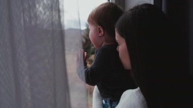 Kafkasyalı bir annenin kollarında oturup ağlayan üzgün bir bebeğin seçici odak noktası. Anne, bebek ve annelik kavramını yatıştırıyor. Sevgi dolu genç bir anneye sarılmak ve küçük kızını yatıştırmak.