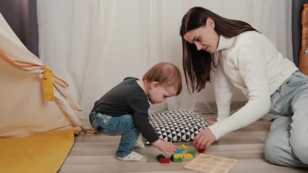 Заботливые Молодая Мать Маленькая Дочь Играют Красочные Небольшие Деревянные Кирпичи — стоковое видео