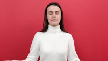 Sakin, genç, beyaz kadın portresi. 20 'li yaşlarda. Avuç içleri açık, yoga meditasyonu yapıyor.