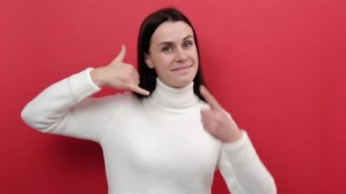 20 'li yaşlarda güzel, genç bir kadının portresi. Kulağına yakın bir yerde telefon ediyor, gülümsüyor, aramasını bekliyor, telefonla bağlantı kuruyor, örgü örüyor, stüdyodaki kırmızı arka plan duvarında izole edilmiş bir süveter giyiyor.