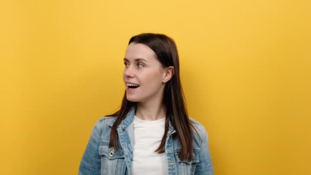 긍정적 머리의 여성이서 동작을 보이고 재킷을 스튜디오의 노란색 고립되어 — 비디오