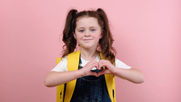 Okouzlující Krásná Školačka Žlutým Batohem Ukazující Ruce Znamení Tvaru Srdce — Stock video