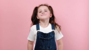 Küçük mutlu kız öğrencinin portresi derin bir nefes alır ya da enerjiyle dolup taşar sağlıklı bir konsept hisseder, pembe stüdyo arka plan duvarında fotokopi alanı ile izole edilmiş poz verir.