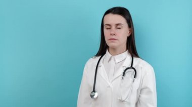 Gerginlik hisseden genç bayan doktorun portresi, mesleki hata için kendini suçlamak. Depresyondaki endişeli kadın terapist, zihinsel yorgunluk düşünüyor, mavi stüdyo arka planında izole edilmiş.