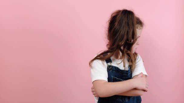 いたずらな子供の概念 不服従の問題 懲罰だ 怒っている女の子子供の肖像画とともに交差腕 ポーズの上にピンク色の背景でスタジオでコピースペース — ストック動画