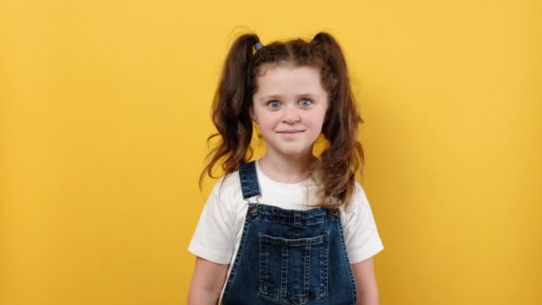 귀엽고 소녀가 시늉을 조용히 스튜디오에 노란색 고립되어 방식의 — 비디오