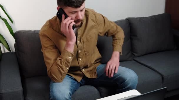 Πλευρική Άποψη Του Νεαρού Καυκάσιου Άνδρα Μιλώντας Τηλέφωνο Και Χρησιμοποιώντας — Αρχείο Βίντεο