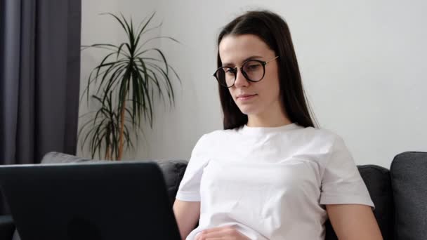Крупным Планом Симпатичной Молодой Женщины Очках Использующей Ноутбук Думающей Новых — стоковое видео