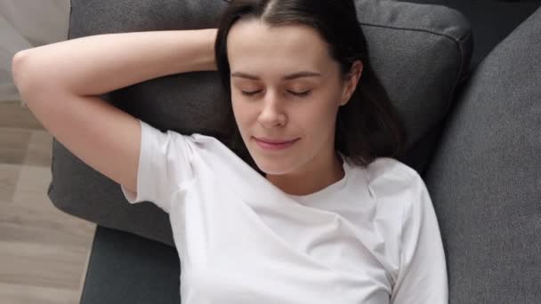 소파에 공기를 들이마시고 실내에서 낮잠을 공상에 잠기는 여성의 여가를 즐기는 — 비디오