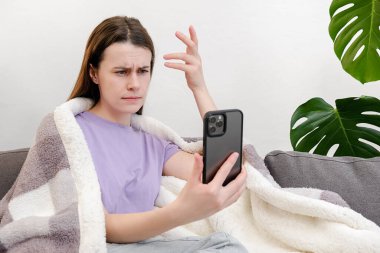 Haberler kötü. Kafası karışmış genç bir kadın, ekoseli kanepeye oturmuş akıllı telefona bakıyor ve önemli bir çağrıyı kaçırdığını görüyor. Umutsuz milenyum hanımı işten çıkarıldığına dair bir mesaj aldı.