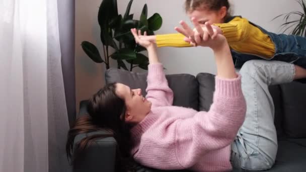 Caring Young Mom Lying Comfy Sofa Back Holding Little Daughter — Stock Video