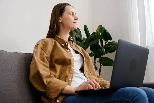 Mulher Jovem Pensativo 20S Sentado Sofá Com Laptop Pensando Inspiração — Fotografia de Stock