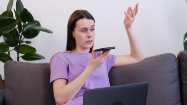 Şirin genç bir bayan rahat kanepesinde dizüstü bilgisayarlı akıllı telefonuyla oturur arkadaşa sesli mesaj gönderir, uzaktan hoparlörle konuşur, işi uzaktan çözer, modern teknolojiyi kullanır. Evden çalışmak