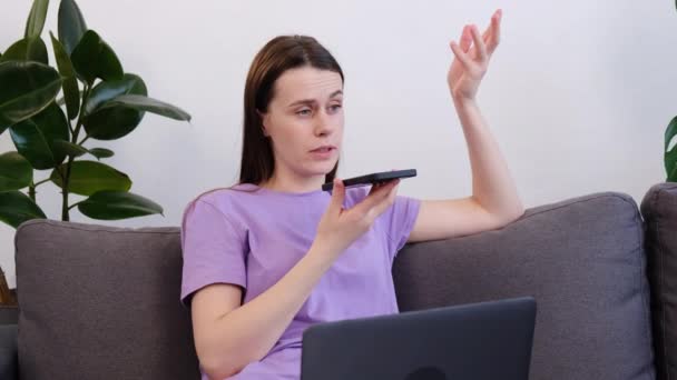 Şirin Genç Bir Bayan Rahat Kanepesinde Dizüstü Bilgisayarlı Akıllı Telefonuyla — Stok video