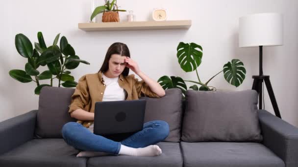 Mujer Estresada Conmocionada Sentarse Sofá Leyendo Malas Noticias Línea Mirando — Vídeos de Stock