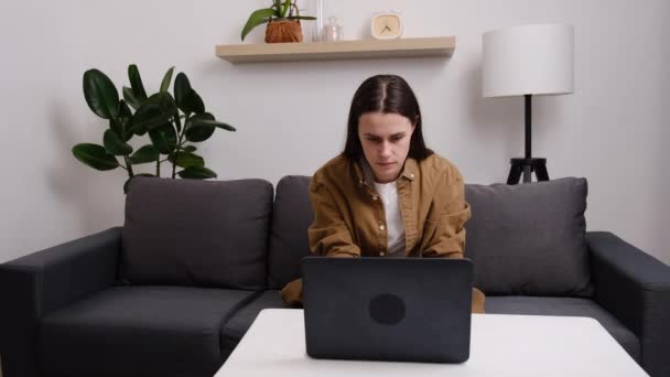 Młoda Brunetka Siedzi Kanapie Czytając Złe Wieści Laptopie Wyglądają Zdesperowane — Wideo stockowe