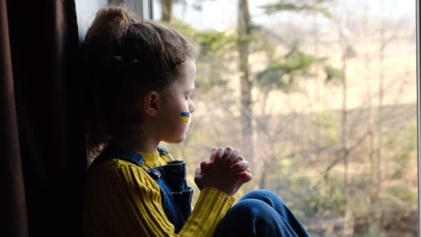 희망에 소녀는 창턱에 앉아우 깃발을 얼굴에 아이를화 나게하는 기도를 러시아의 — 비디오