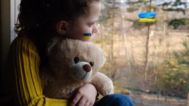 Smutna Dziewczynka Flagą Ukrainki Twarzy Trzymająca Puszystego Misia Siedzącego Samotnie — Wideo stockowe