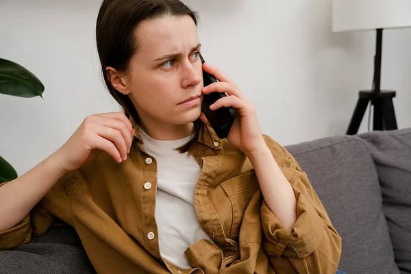 Endişeli genç bir bayan telefonla arıyor, akıllı telefonla konuşuyor, evde yalnız başına kötü haberler alıyor. Ayrılık, stres, işte ya da ilişkilerde sorunlar, korku, olay olduğunda endişe. Negatif insan duyguları