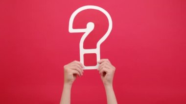 İş, planlar, düşünceler ve reklam konsepti. Stüdyoda kırmızı arkaplan duvarında izole edilmiş ve promosyon içeriği için fotokopi alanı olan büyük soru işareti işareti işareti olan kadın ellerini kapatın.