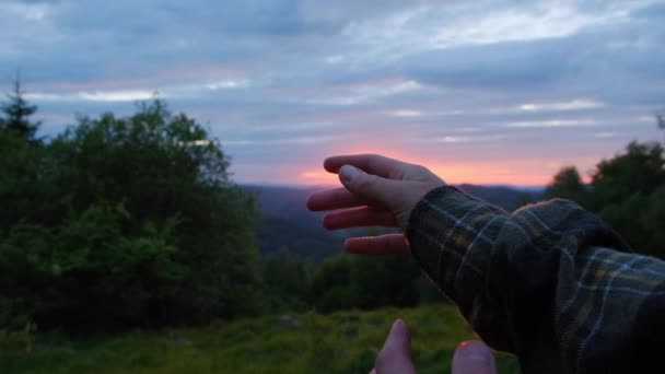 カップルが手を取り合い 夕日の上でお互いの指を愛撫するバックビューは 夏の素晴らしい山々 愛との関係で美しい夜を埋めました ロマンチックな自然と放浪者の概念 — ストック動画