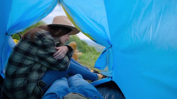 年轻的游牧民族夫妇在露营帐篷里享受着懒洋洋的冒险生活 快乐的年轻女子头戴礼帽望着篝火 呼吸着新鲜空气 旅行概念 — 图库视频影像
