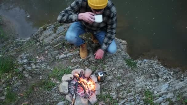 Tampilan Utama Pemuda Minum Kopi Panas Dekat Api Unggun Hutan — Stok Video