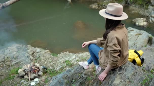 Eine Fröhliche Junge Touristin Mit Hut Sitzt Auf Einem Stein — Stockvideo