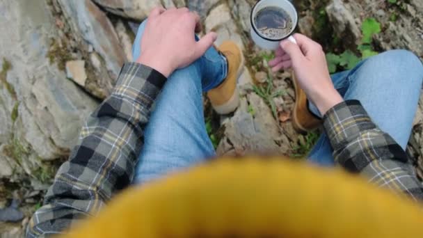 清晨时分 远足的年轻人坐在山河或湖边的石头上 享受着白杯热咖啡的美丽自然美景 冒险户外流浪情欲 探索旅行概念 — 图库视频影像