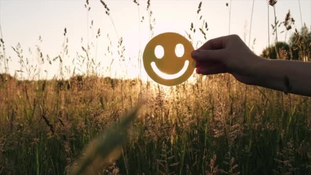 Female Hand Holding Happy Face Emoticon Green Grass Background Amazing — Stock Video