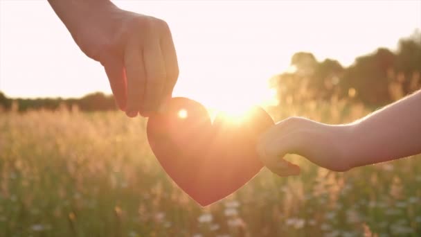 关爱和关系概念 在夏日美丽的日落或日出时分 与女儿手牵着小红心的母亲的亲密接触 — 图库视频影像