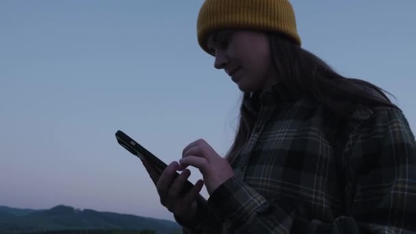 Молодая Женщина Открытом Воздухе Вечерние Сумерки Прокрутки Через Корм Смартфоне — стоковое видео