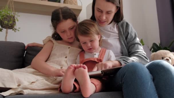Fürsorgliche Junge Mutter Liest Interessantes Buch Niedlichen Kleinen Töchtern Familie — Stockvideo