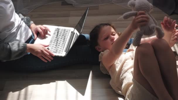 Вид Сбоку Молодой Мамы Работает Компьютером Рядом Маленькой Дочкой Играющей — стоковое видео