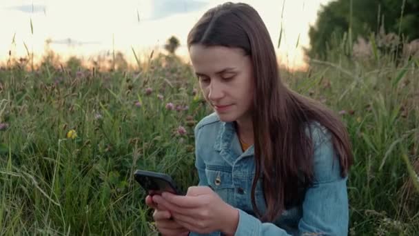 Zrelaksowana Młoda Kobieta Przewijać Aplikacje Karmić Smartfonie Patrząc Zachód Słońca — Wideo stockowe